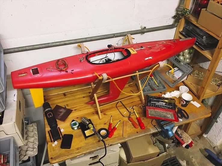 rc sailboat on a table with tools
